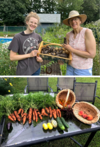 Celia poses with potatoes, carrots, cucumbers and squash from her garden.
