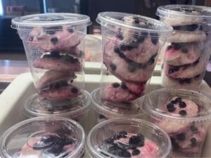 Display of plastic cups with blueberry smoothie bites and blueberry garnish
