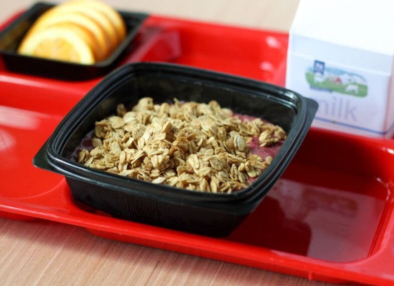 Cherry Lime Smoothie bowl with oats on tray with milk and orange slices