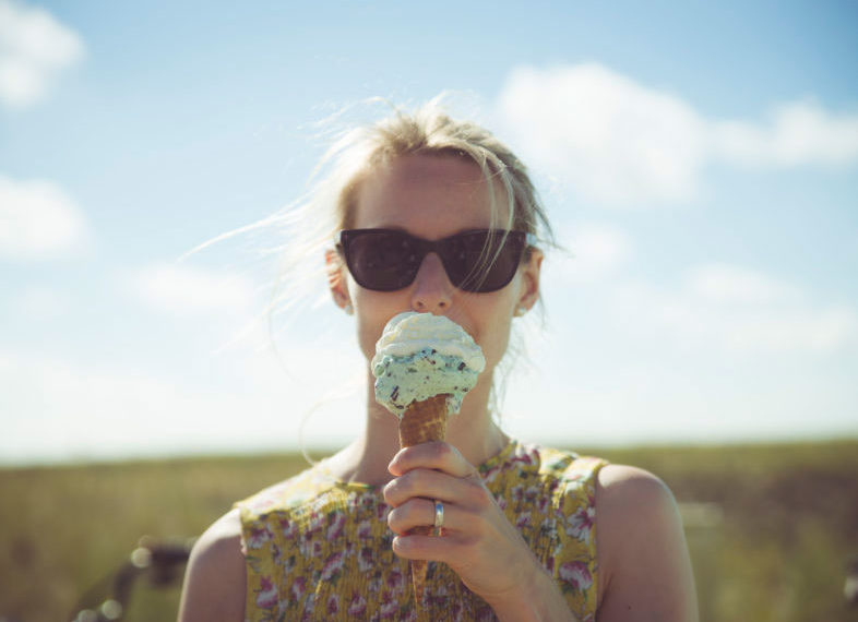 Woman eating ice cream in field