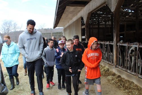 Students on the dairy farm with Patriots player