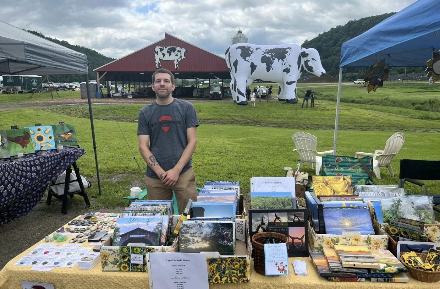 Man on a farm with table full of art