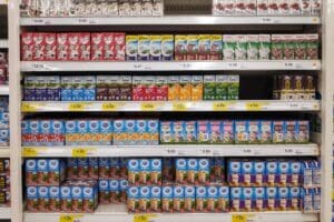 Grocery store shelves showing a variety of shelf stable milk options.